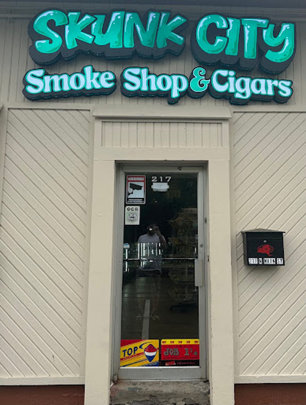 Skunk City Smoke Shop & Cigars storefront sign at 217 N Main St